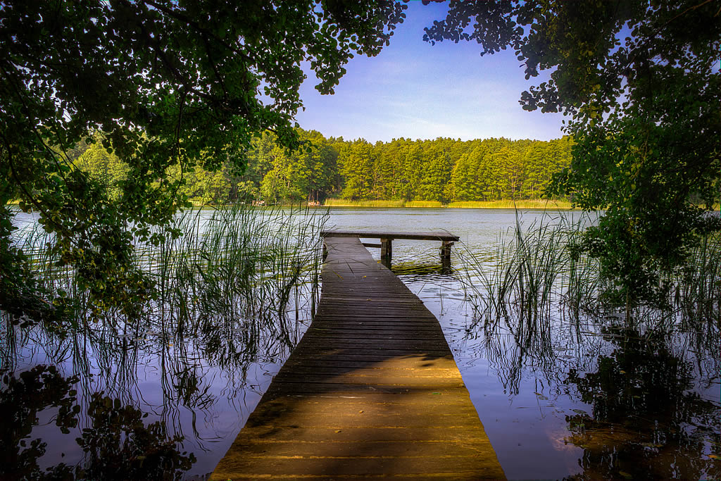 Image of a jetty at Lübbesee by Ahlimbsmühle, site of the festival Adventure Team are playing at on the 29th of April, 2023.